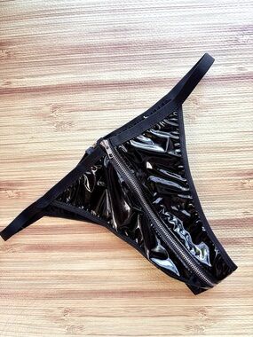 shiny black faux leather thong features a prominent front-to-back zipper closure